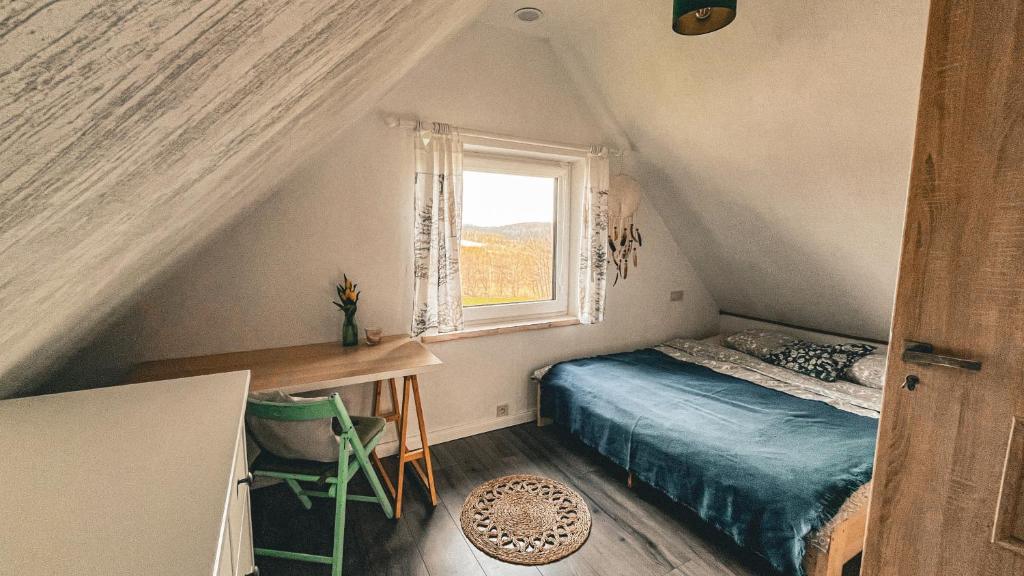 a small bedroom with a bed and a window at Chatka Biesczadersko in Lutowiska