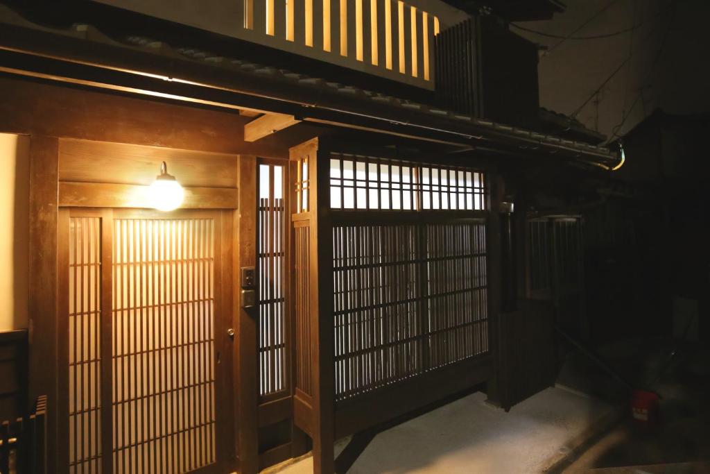 an entrance to a room with two doors and a light at And Machiya Inn in Kyoto