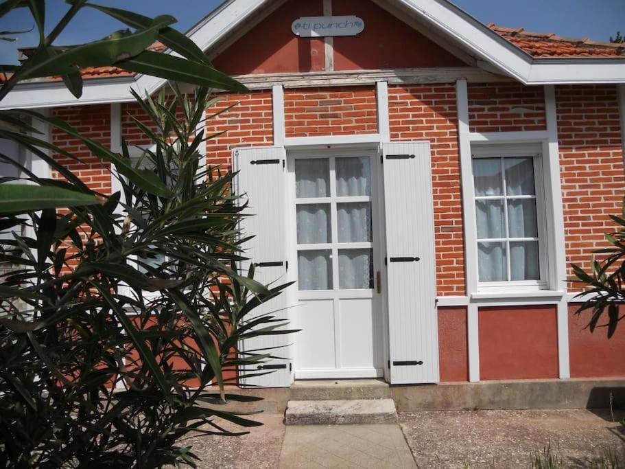 a red brick house with a white door and windows at Villa centre-ville proche plage -6264 in Soulac-sur-Mer