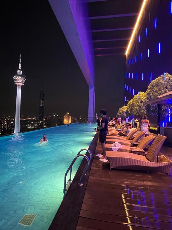 a pool at a hotel with people in the water at night at Vinson Suites at Platinum KLCC in Kuala Lumpur