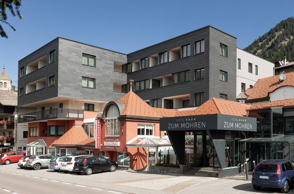 a street with cars parked in front of a building at Hotel Zum Mohren in Resia