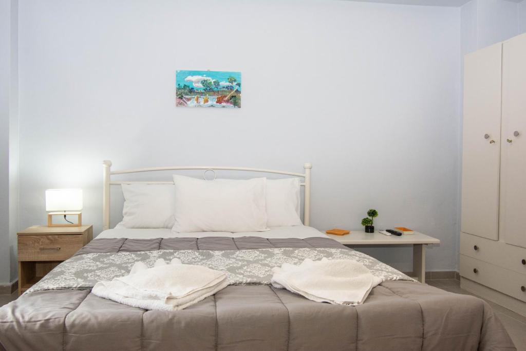 een slaapkamer met een bed met twee handdoeken erop bij Traveller's Nest Studio close to center,port,airport in Heraklion
