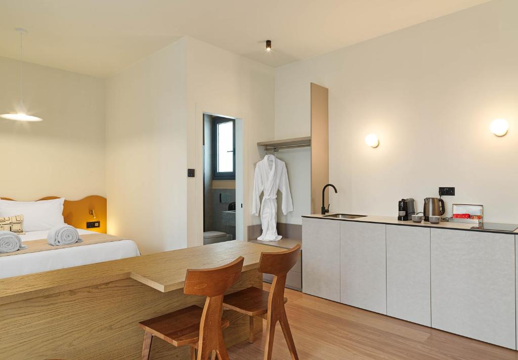 a bedroom with a bed and a table and a kitchen at Alinea Market Agora Square in Limassol