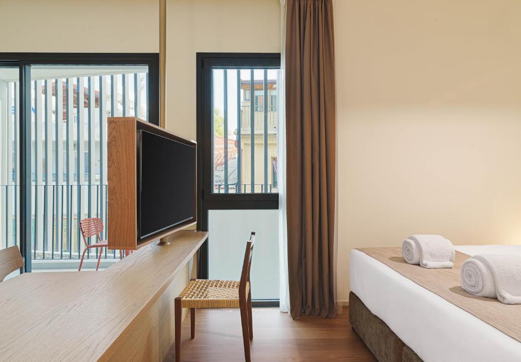 a hotel room with a bed and a tv and a window at Alinea Market Agora Square in Limassol