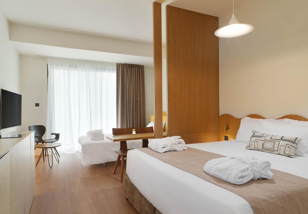 a hotel room with a large bed and a desk at Alinea Market Agora Square in Limassol