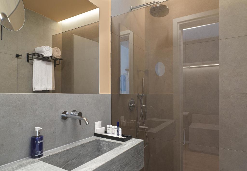 a bathroom with a tub and a shower with a glass door at Alinea Market Agora Square in Limassol