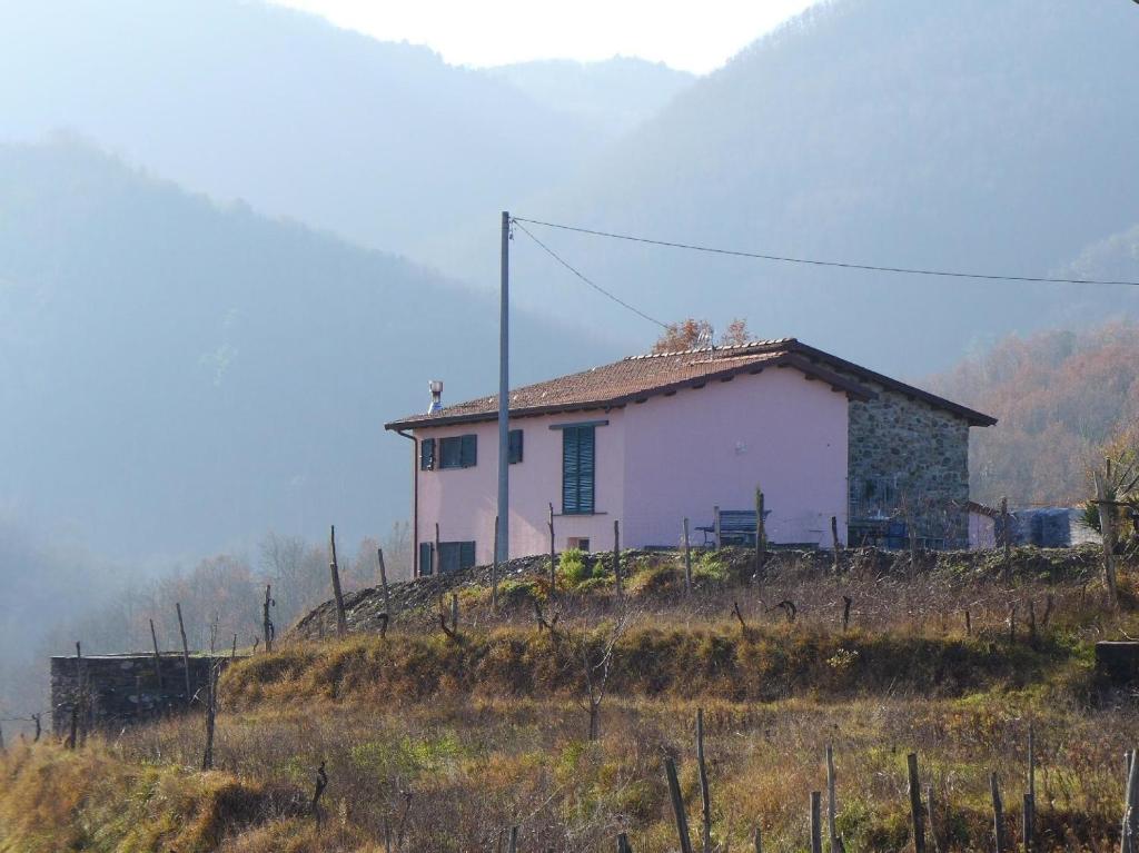 una casa blanca en la cima de una colina en Mini-Appartement Casa Colombana mit Panoramablick, en Aulla