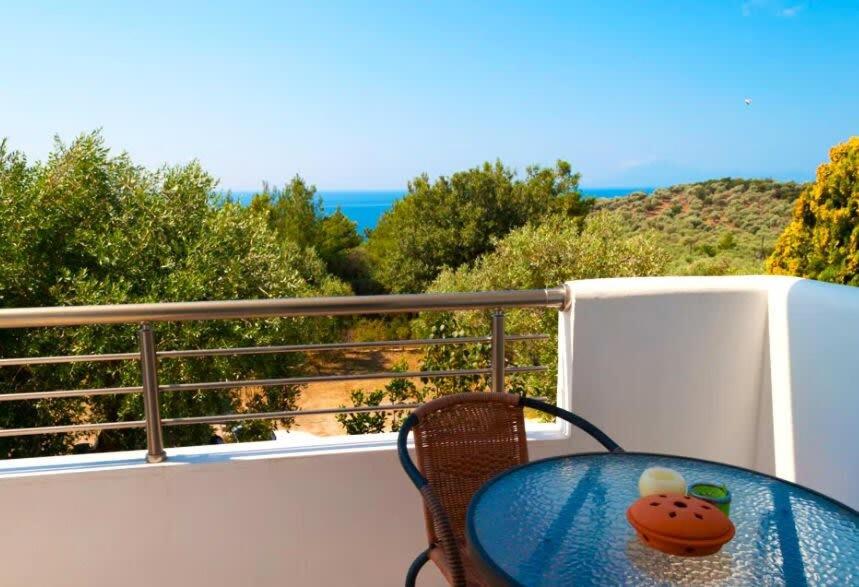 a table on a balcony with a view of the ocean at Thasos Seaside Serenity - Seaview & Garden Nests in Astris