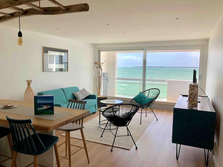 un salon avec un canapé bleu et des chaises dans l'établissement Une vue panoramique sur la baie de Concarneau, à Concarneau