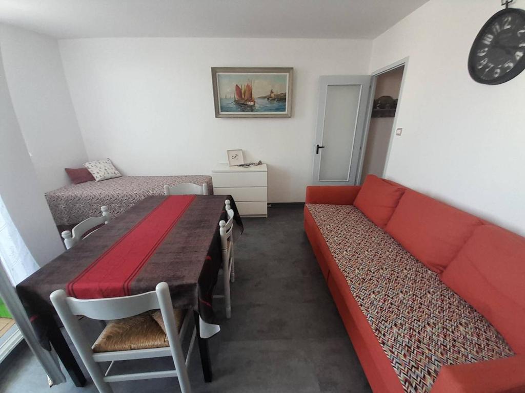 uma sala de estar com um sofá vermelho e uma cama em Appartement Saint-Hilaire-de-Riez, 2 pièces, 4 personnes - FR-1-324A-27 em Saint-Hilaire-de-Riez