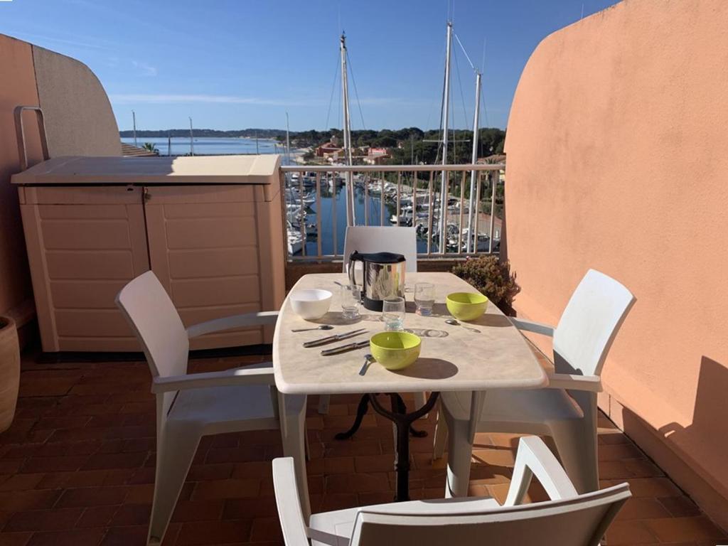 stół i krzesła na balkonie z widokiem w obiekcie Duplex climatisé 4 pers, balcon, parking privé, proche plages et commerces - FR-1-335-168 w Hyères