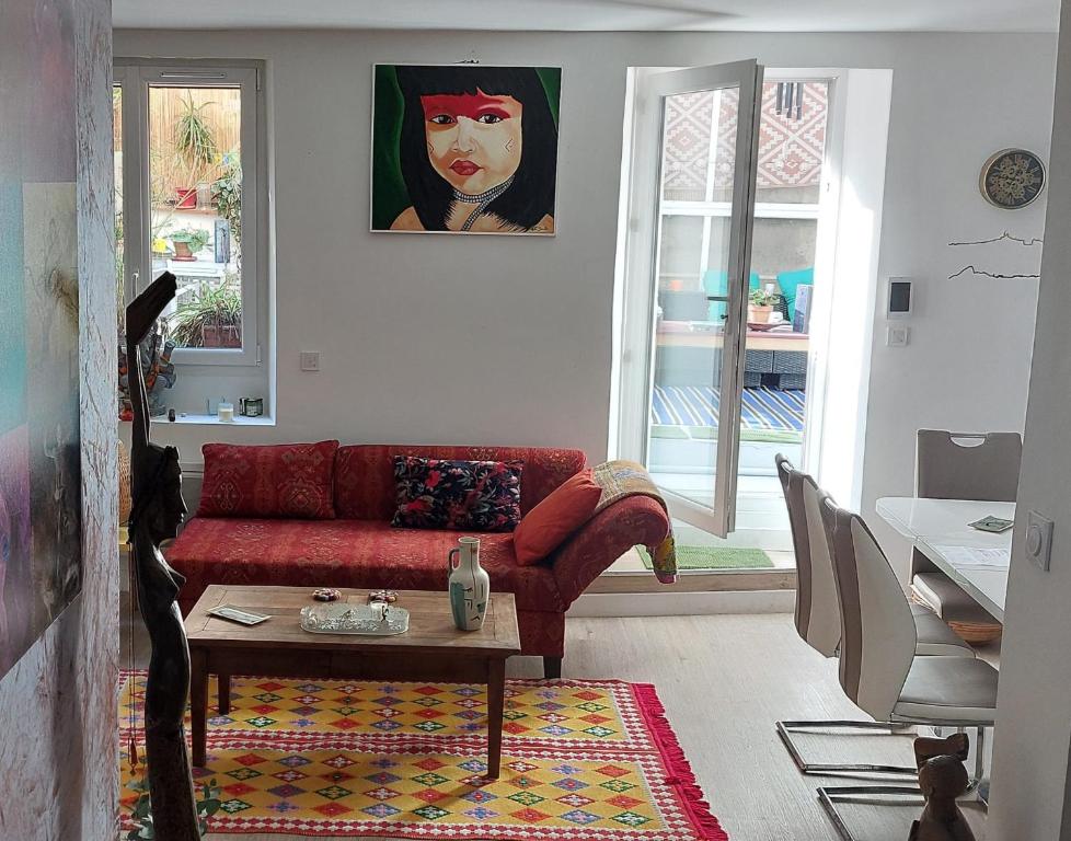 a living room with a red couch and a table at Cosy Appart in Marseille