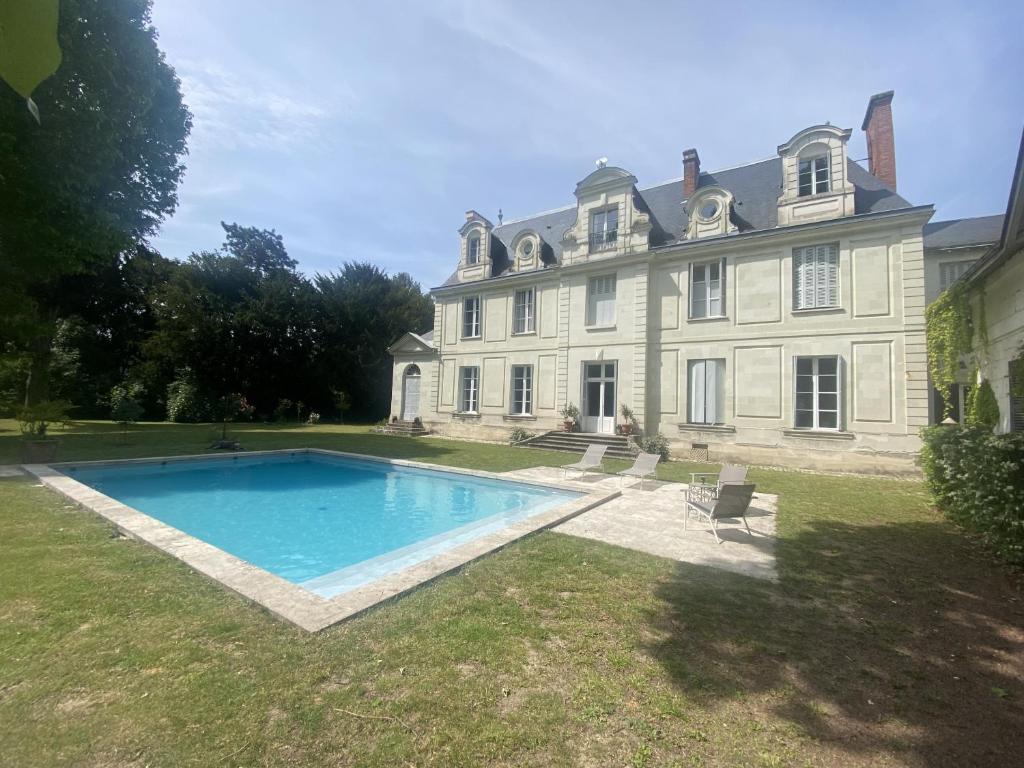 une grande maison avec une piscine en face de celle-ci dans l'établissement La Grande Carrée, à Saint-Cyr-sur-Loire