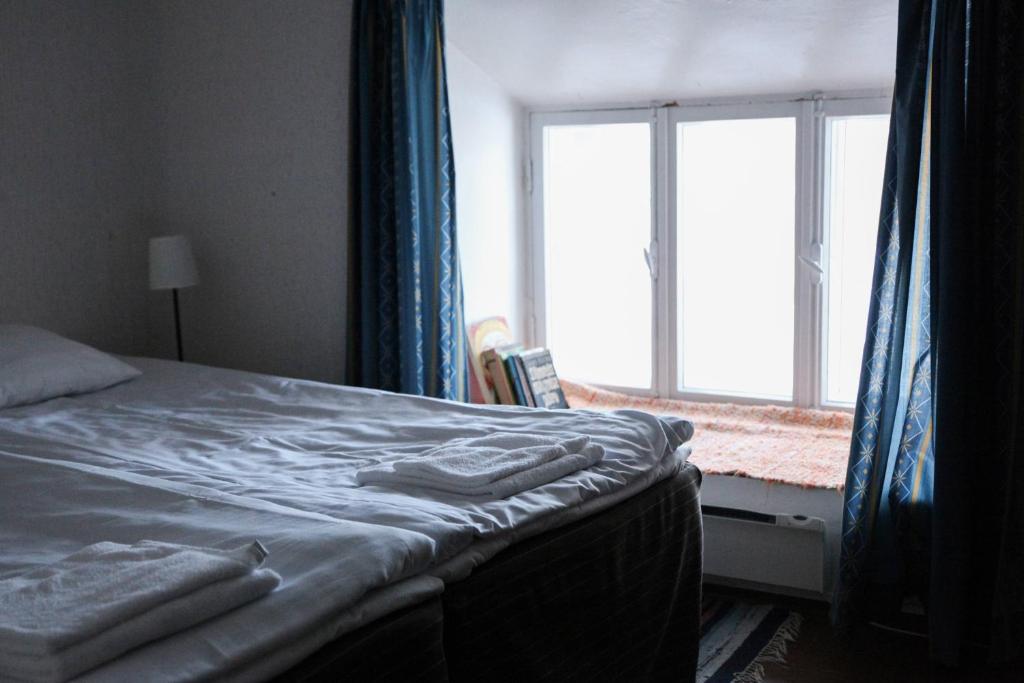a bedroom with a bed and a window with blue curtains at Utoopia nr 9 in Kõrgessaare