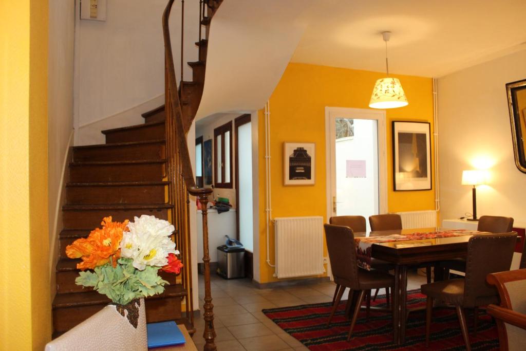 a dining room and living room with a table and a staircase at Maison de Charme 95m2 à Saint-Denis PLEYEL, 4 Chambres, Terrasse, Calme, Proche Paris et Stade de France in Saint-Denis