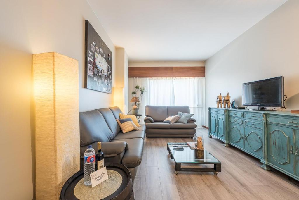 a living room with a couch and a television at GuestReady - Woodwork Apartment in Porto