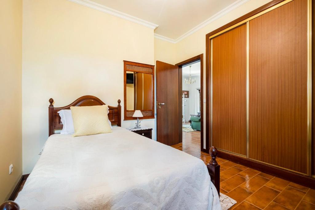 een slaapkamer met een bed en een houten kast bij Vintage charm meets modern comfort 3 in Aguda