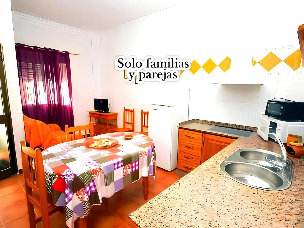 een keuken met een tafel en een wastafel in een kamer bij Apartamentos Noria Familias y Parejas Gold in Conil de la Frontera