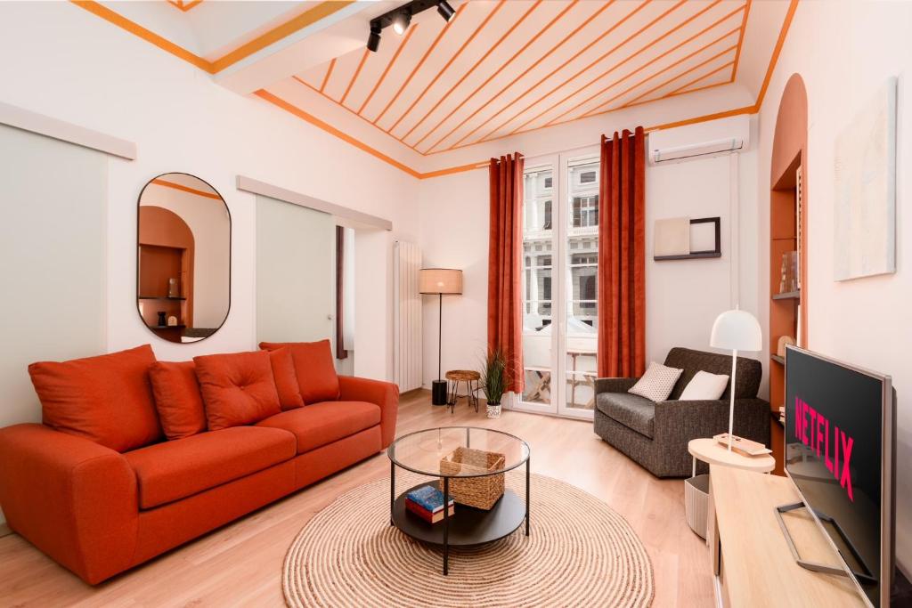 een woonkamer met een rode bank en een tv bij Esclusivo ed unico nel cuore di Genova in Genua
