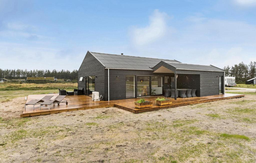 une petite maison avec une terrasse en bois dans un champ dans l'établissement Gorgeous Home In Saltum With Sauna, à Saltum