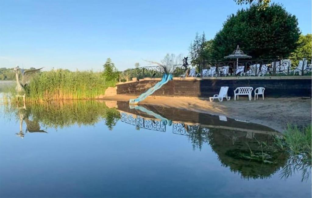 WęgorzynoCozy Apartment In Wegorzyno With Wifi的桌椅,享有水面的景色