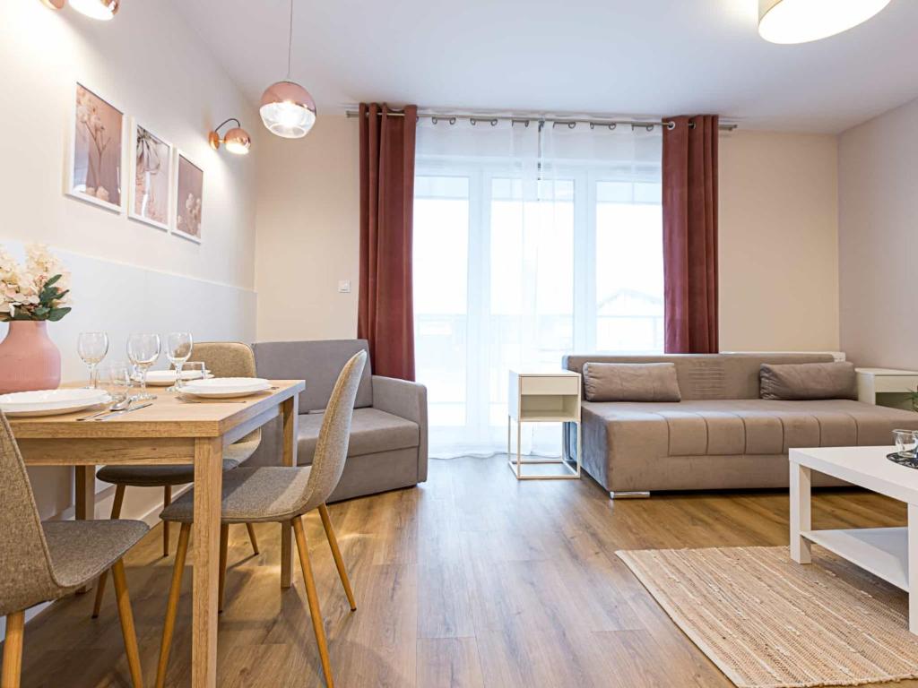 a living room with a couch and a table at VacationClub - Apartamenty Zakopiańskie Apartament 34 in Zakopane