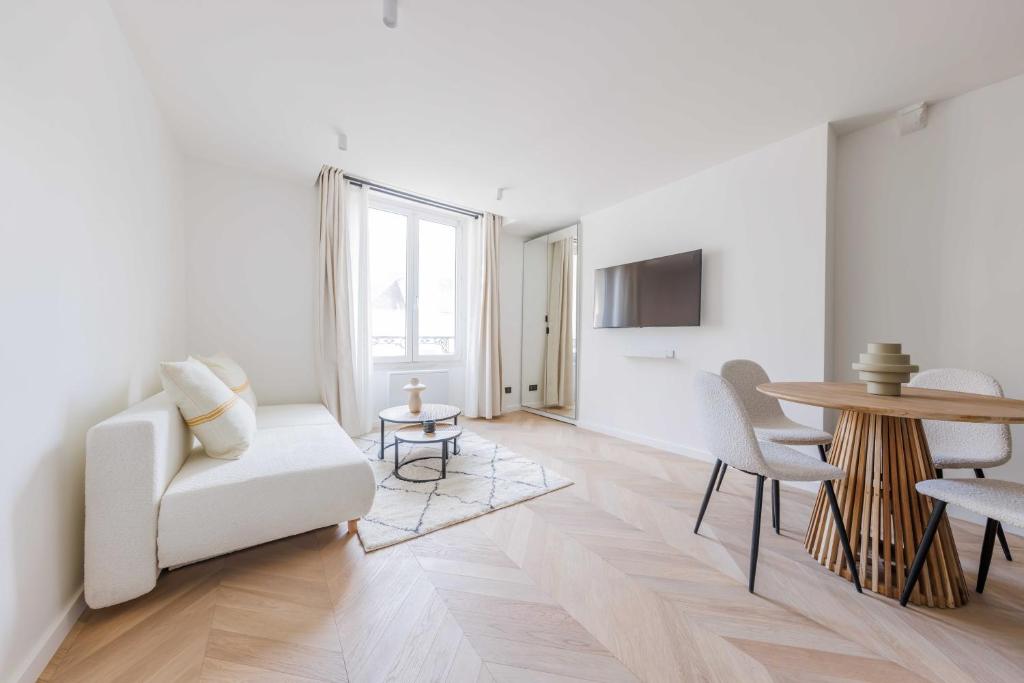 un salon avec un canapé blanc et une table dans l'établissement Charming apartment - 1BR-4P - Le Marais, à Paris