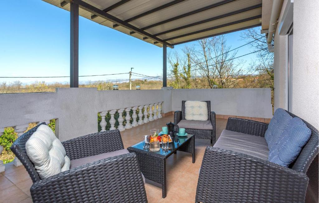 Un patio con sillas de mimbre y una mesa. en 3 Bedroom Amazing Home In Malinska, en Županje