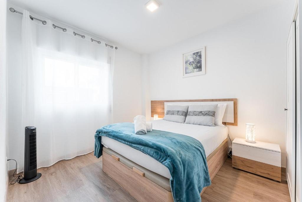 a bedroom with a bed with a blue blanket on it at Trendy comfort in Vila Nova de Gaia in Vila Nova de Gaia