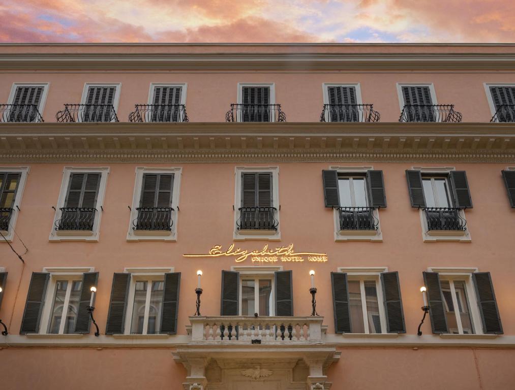 a pink building with windows and a balcony at Elizabeth Unique Hotel | a Member of Design Hotels™ in Rome