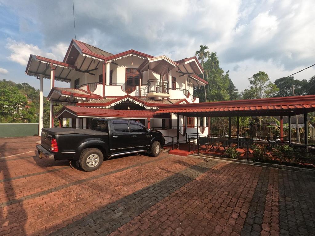 a black truck parked in front of a house at Rafting Reach Layathraa in Nawalapitiya