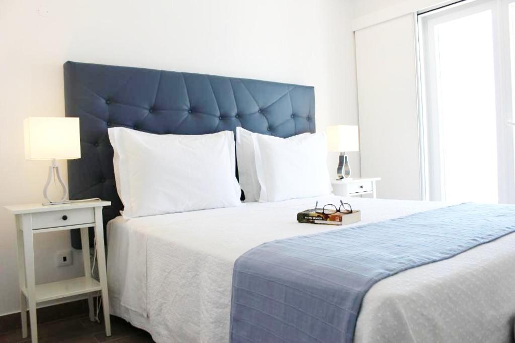 ヴィラ・ノヴァ・デ・ミルフォンテスにあるRiver Inn - Duna Parque Groupのベッドルーム1室(大型ベッド1台、青いヘッドボード付)