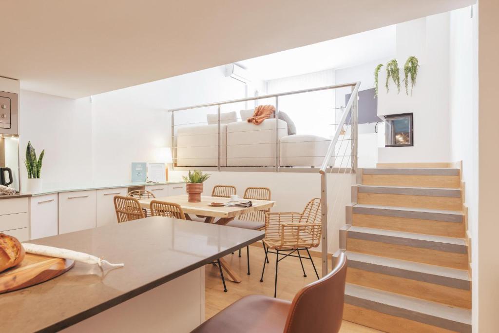 cocina y comedor con escalera, mesa y sillas en Bravissimo Hortes, 3-bedroom centre apartment, en Girona