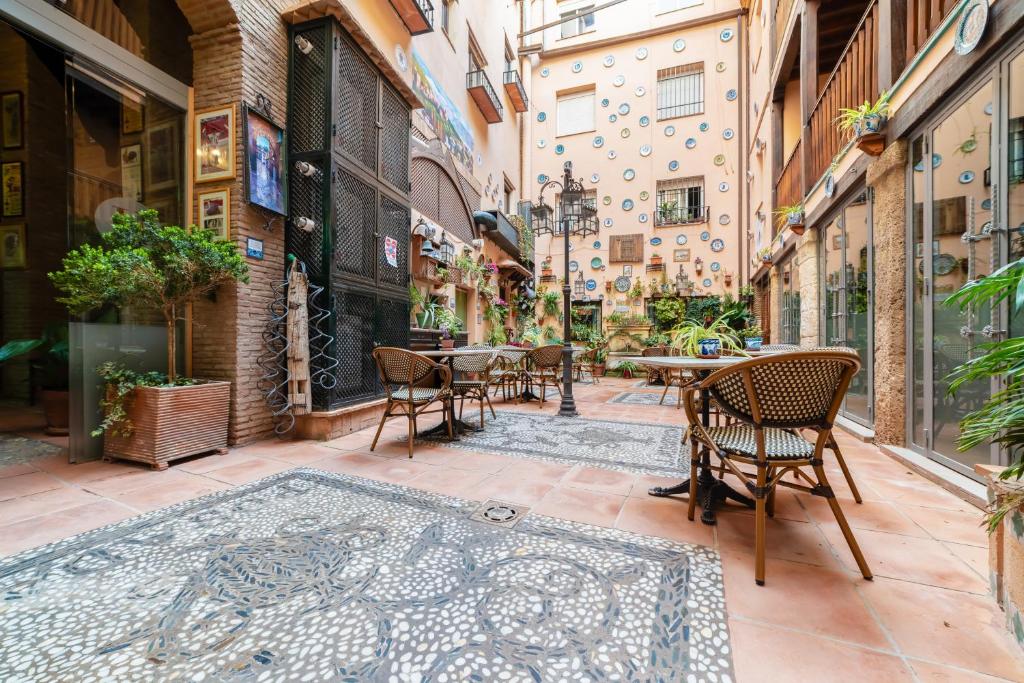 un callejón con mesas y sillas en un edificio en Hotel Posada del Toro, en Granada