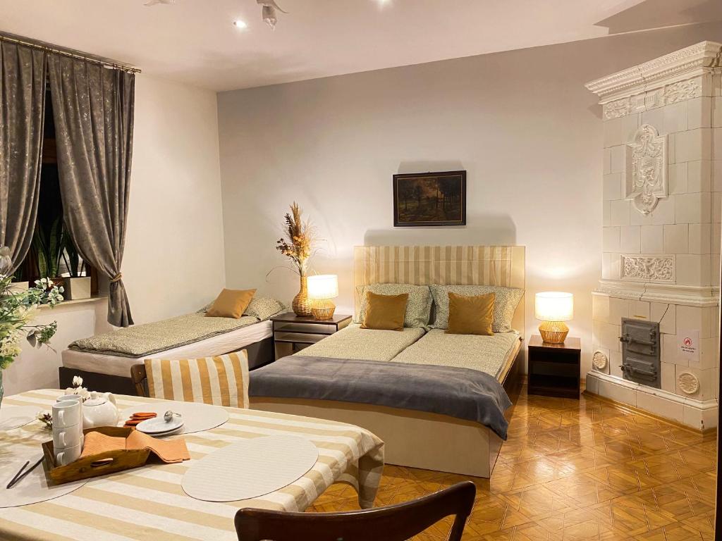 a hotel room with two beds and a table and a dining room at Apartament Familijny in Przemyśl