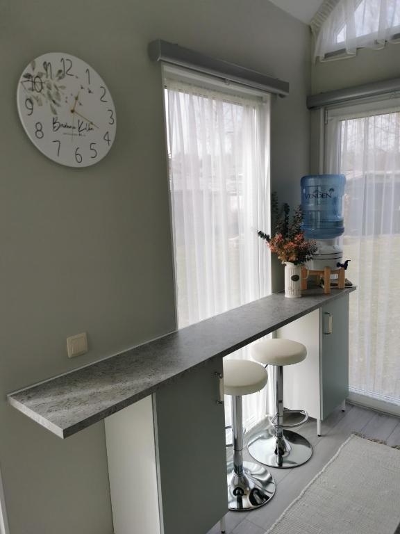 a kitchen with a counter and a clock on the wall at Rietumi in Kolka