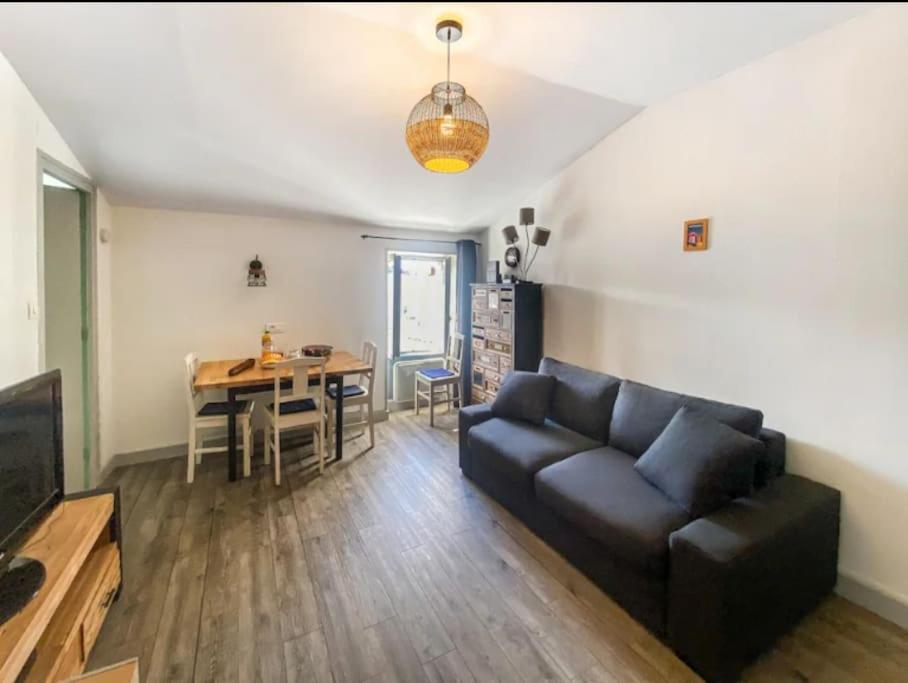 ein Wohnzimmer mit einem Sofa und einem Tisch in der Unterkunft Appartement T2 idéalement placé vieux port in La Rochelle