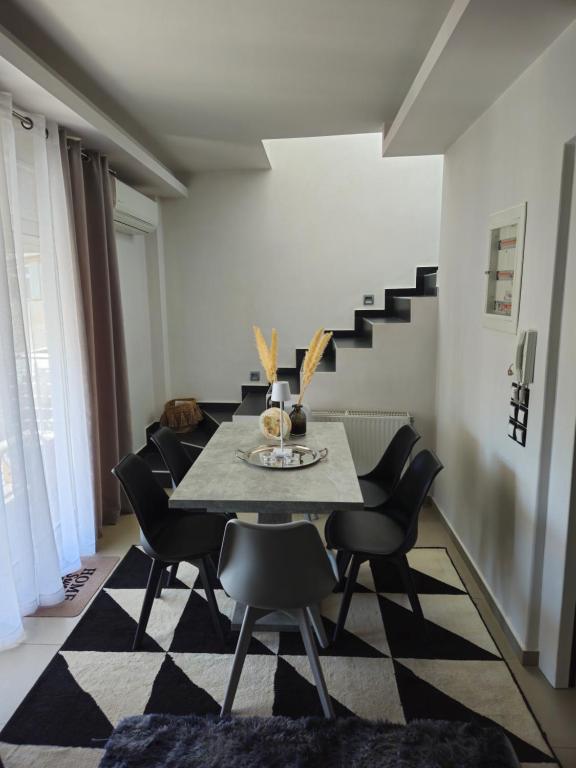 a dining room with a table and black chairs at Mary's luxury apartment Nemea in Neméa