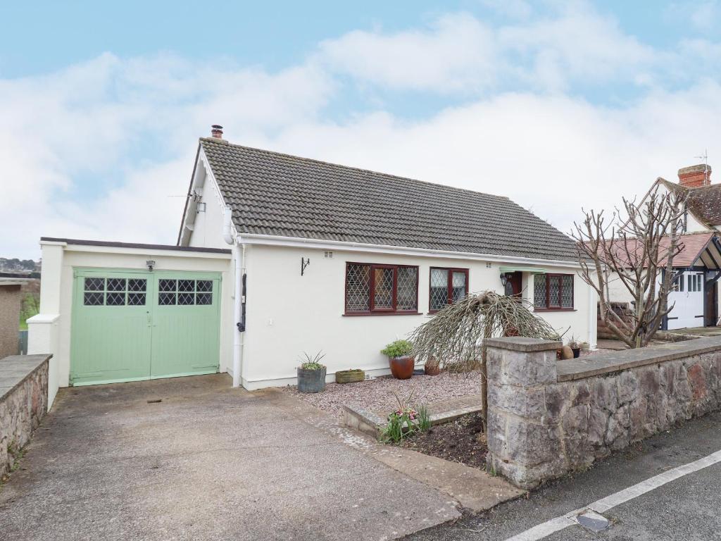 a white house with a green garage at The Crib in Llandudno