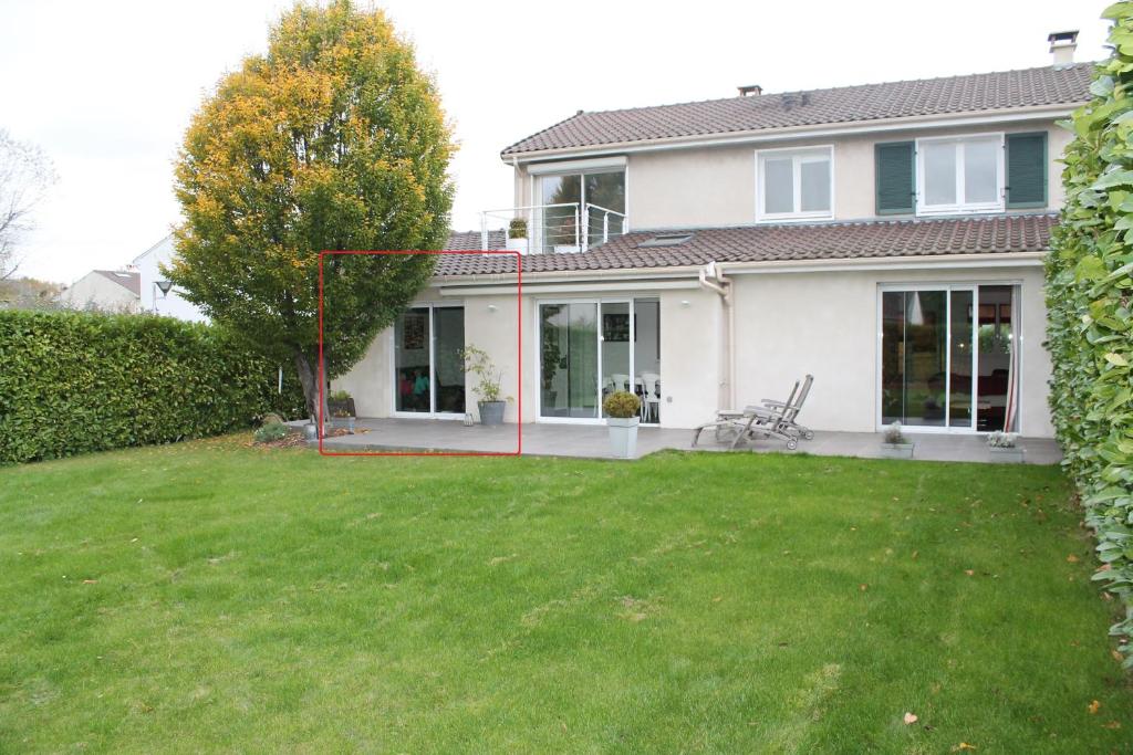 une maison avec une grande cour devant elle dans l'établissement Séjournez chez Cédric et Julie, à Montesson