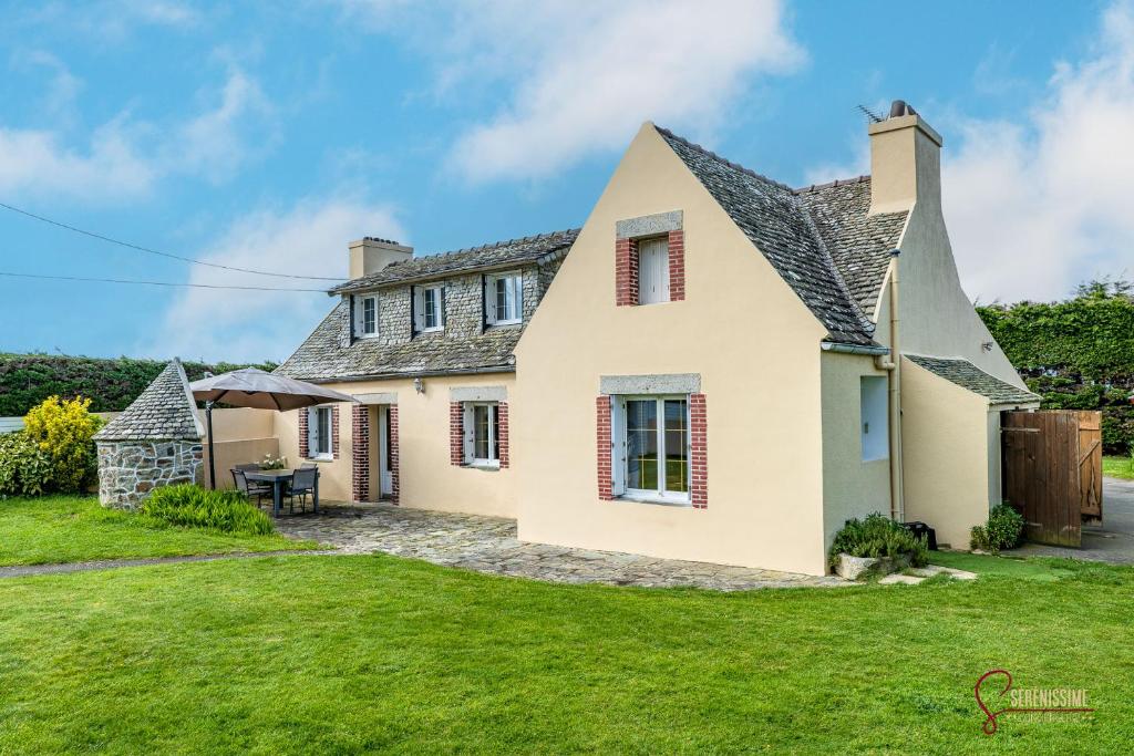 een huis met een groen gazon ervoor bij La maison de la petite lande in Saint-Jean-du-Doigt