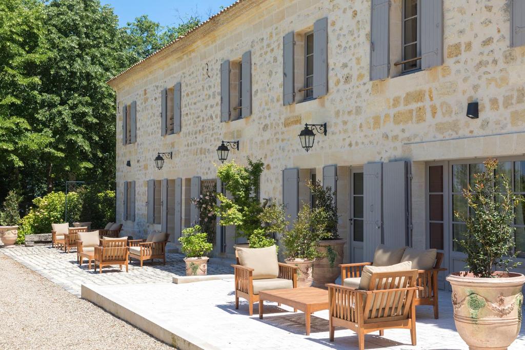 a group of chairs and tables in front of a building at Les Clefs de Troplong Mondot in Saint-Émilion