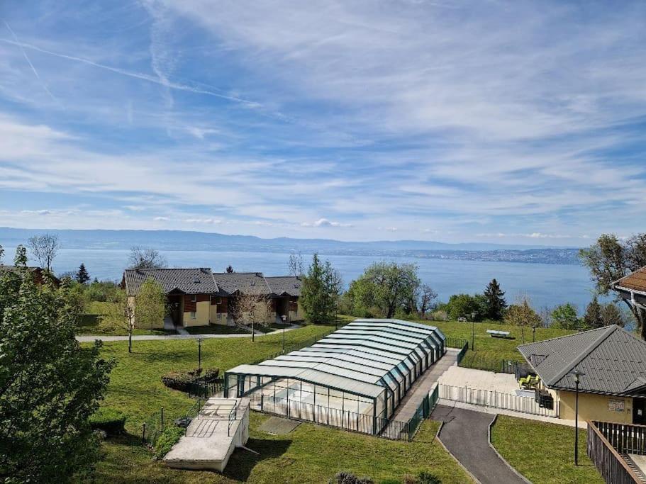 a greenhouse in a field with a view of the water at Lugrin proche du Lac et Montagne in Lugrin