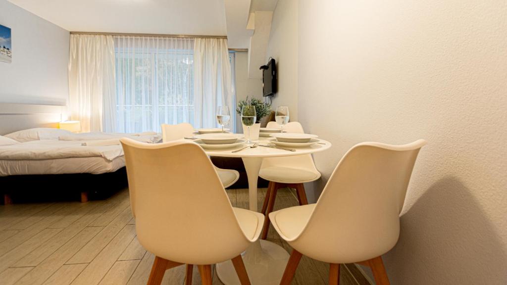ein Esszimmer mit einem Tisch, Stühlen und einem Bett in der Unterkunft VacationClub - Livigno Apartament 28 in Heudorf