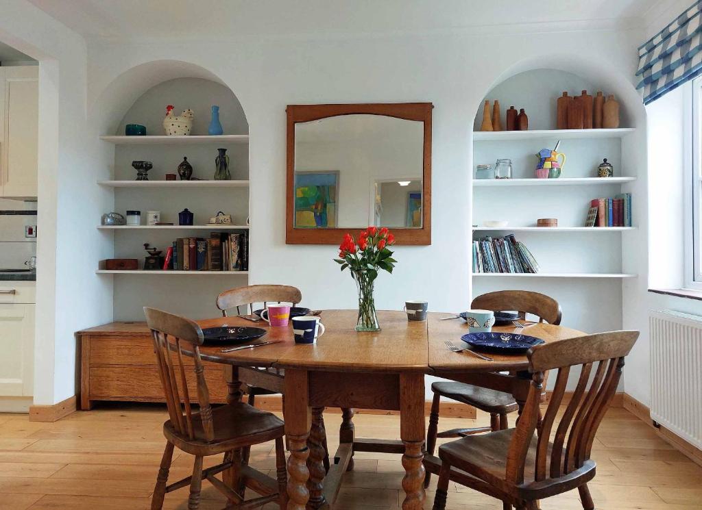 uma mesa de jantar com cadeiras e um espelho em Garreg Wen - White Stone, family holiday home em Barmouth