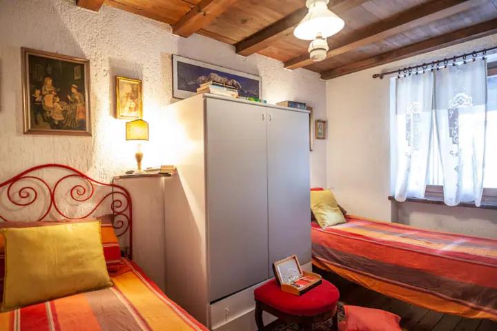 Pokój z 2 łóżkami i dużą białą szafką w obiekcie Spacious chalet low-cost for a group holiday w mieście Courmayeur