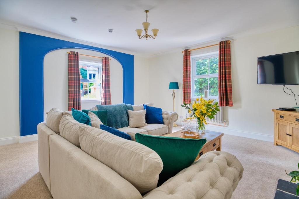 a living room with a couch and a tv at Enholmes Coach House in Hull