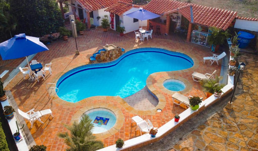 an overhead view of a swimming pool with chairs and umbrellas at Finca Villa Alicia in Barichara