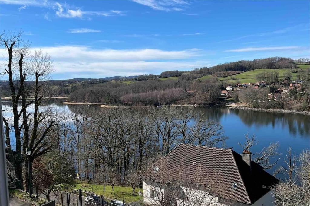 a view of a lake with a house in the foreground at Maison au bord du lac in Saint-Étienne-Cantalès