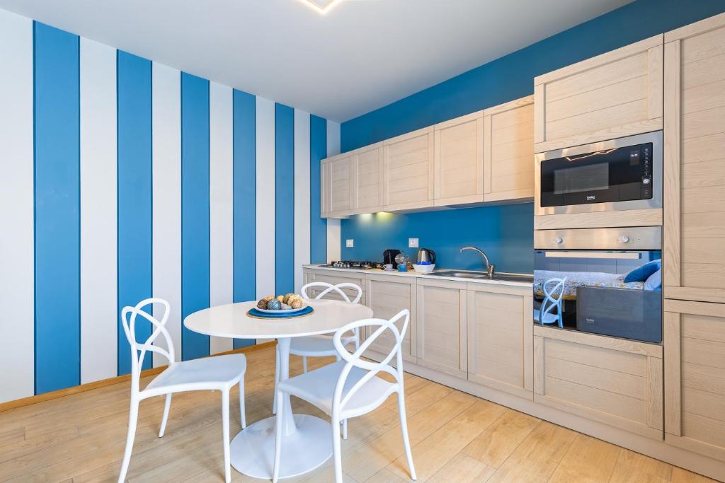una cocina con paredes de rayas azules y blancas, mesa y sillas en La Casa Nelle Aie - Appartamento Dolcetto - Private Parking - Free Wifi & AC, en La Morra